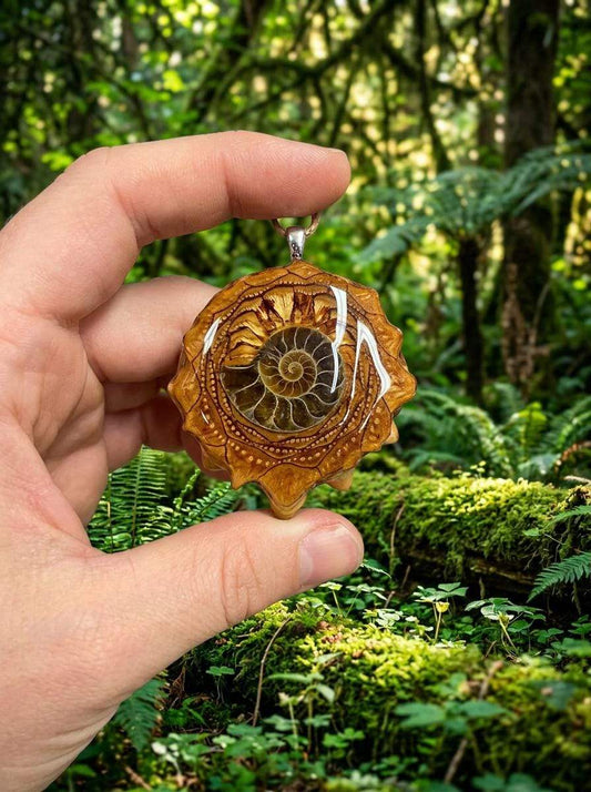 Hand holding resin pendant with ammonite fossil, forest background, custom wire wrap jewelry