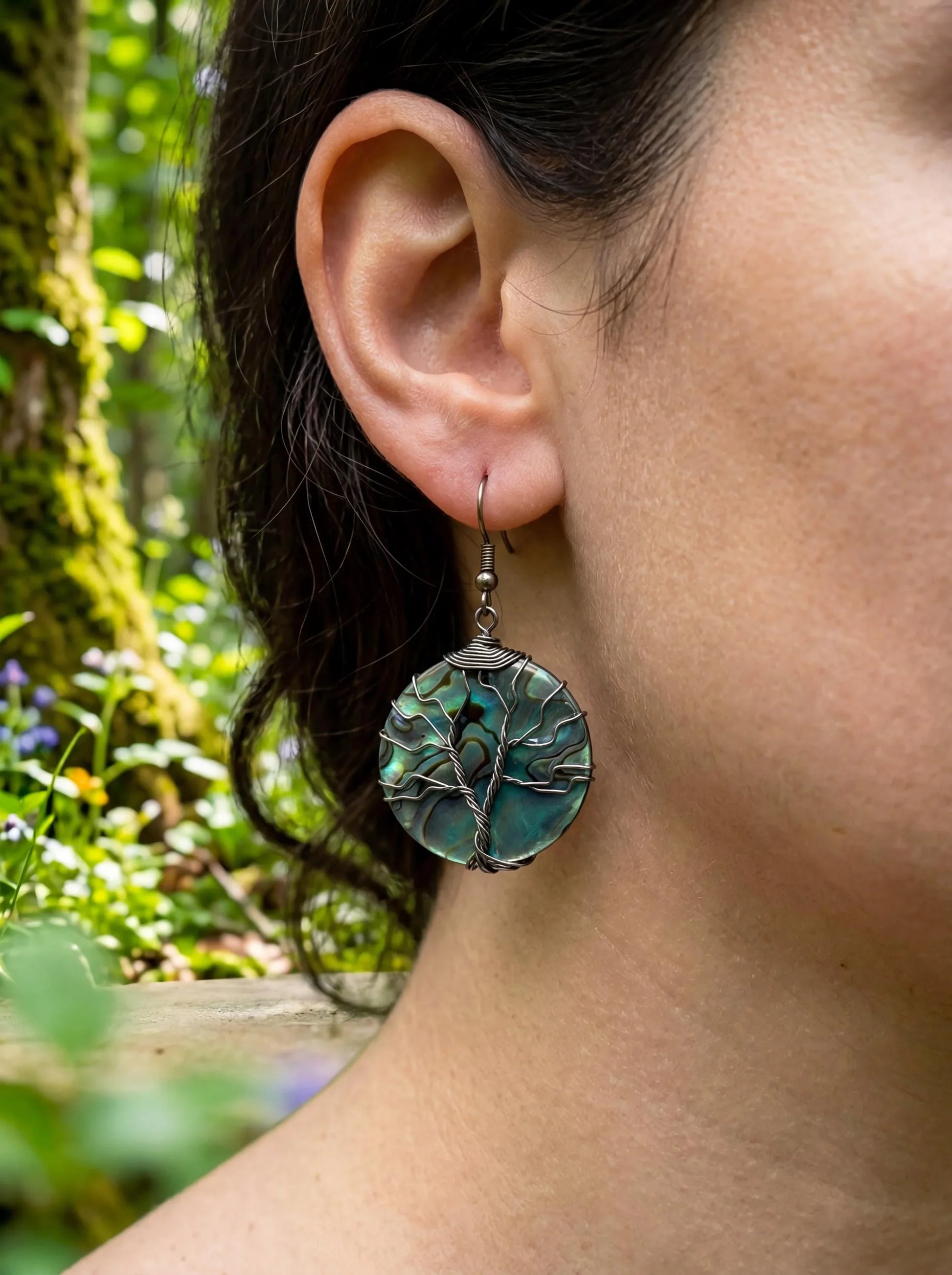 Wire-wrapped abalone shell tree of life earring, nature-inspired jewelry with forest backdrop