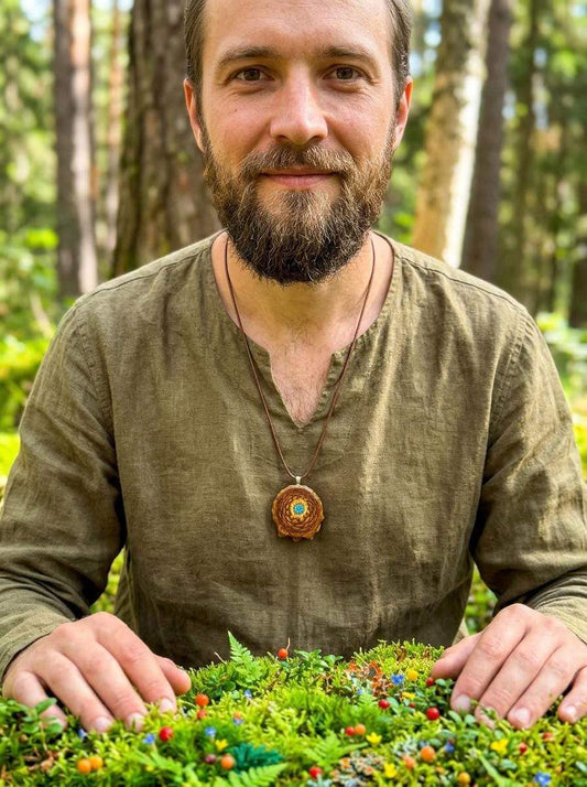 Man wearing handmade pinecone pendant necklace in forest setting